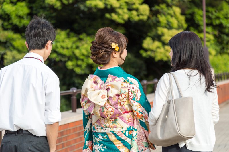 振袖を着た女性と家族の後姿